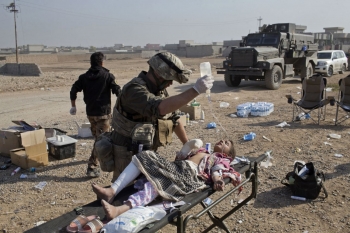 Un medico volontario americano cura una ragazza irachena ferita