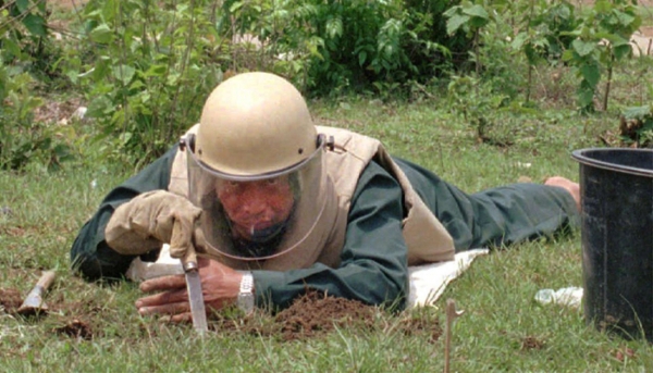 Un tecnico de Laos tasta il terreno in cerca di esplosivi eredita&#039; della guerra segreta.