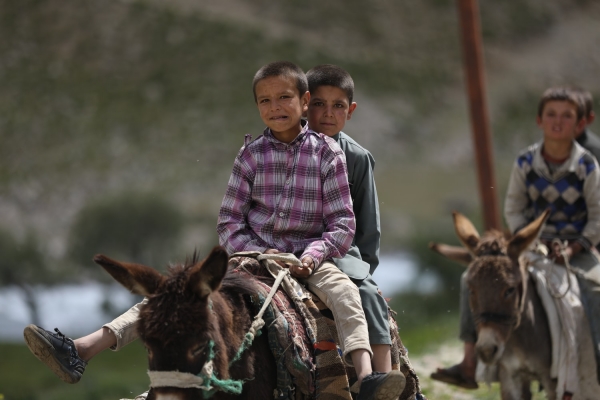 due bambini afgani sfollati vanno a cavallo