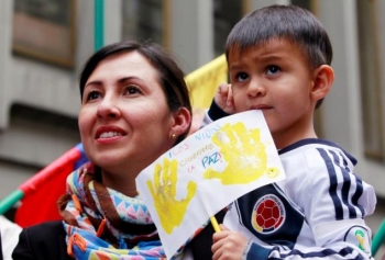 Una donna con suo figlio celebrano la firma dello storico cessate il fuoco a Bogotà