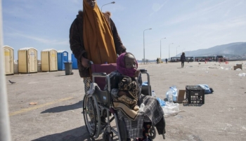 Una madre di una bambina disabile spinge la sua carrozzina 