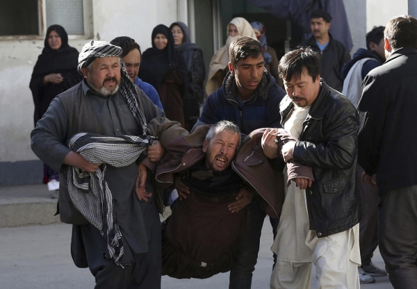 Un uomo sconvolto è trasportato dalla scena delle esplosioni a Kabul, Afghanistan