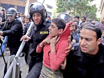 Giovane arrestato dalla polizia egiziana durante una protesta al Cairo. 
