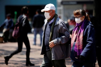 Persone che camminano in strada indossano le mascherine protettive a Bogota, Colombia, 17 marzo 2020