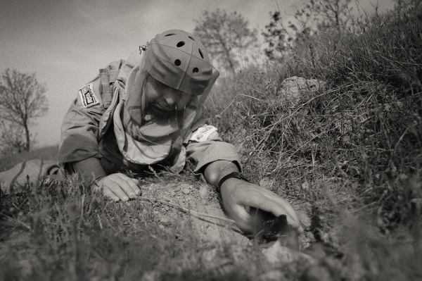  A MAG deminer places an explosive charge next to an unexploded BLU97 cluster munition