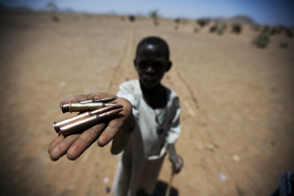 Sudanese child holds up bullets, North Darfur 